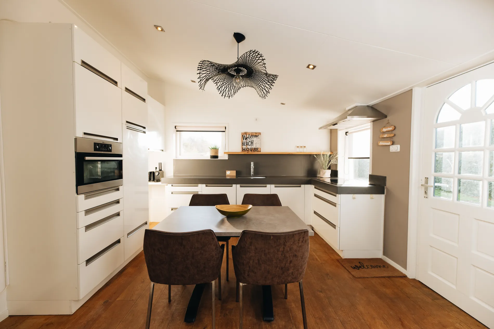 Moderne witte keuken met eethoek in de 6-persoons vakantiewoning van Resort Land & Zee.